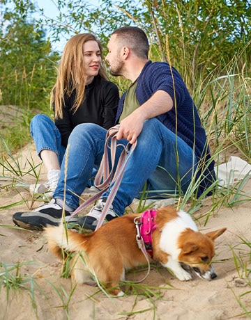 find sober living for | husband wife on the beach with their Corgi sober happily married in recovery