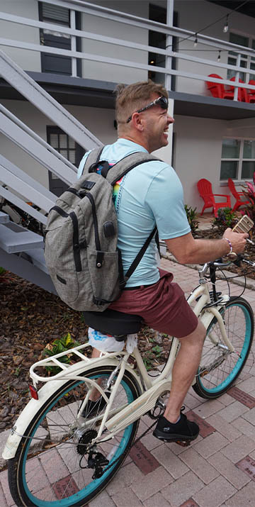 sober living | sober living resident coming home from work on a bike conversation and laughing